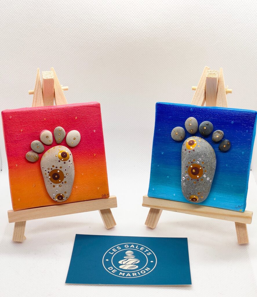 2petites toiles peintes sur chevalet avec galets peints en forme de pied fond rose et fond bleu