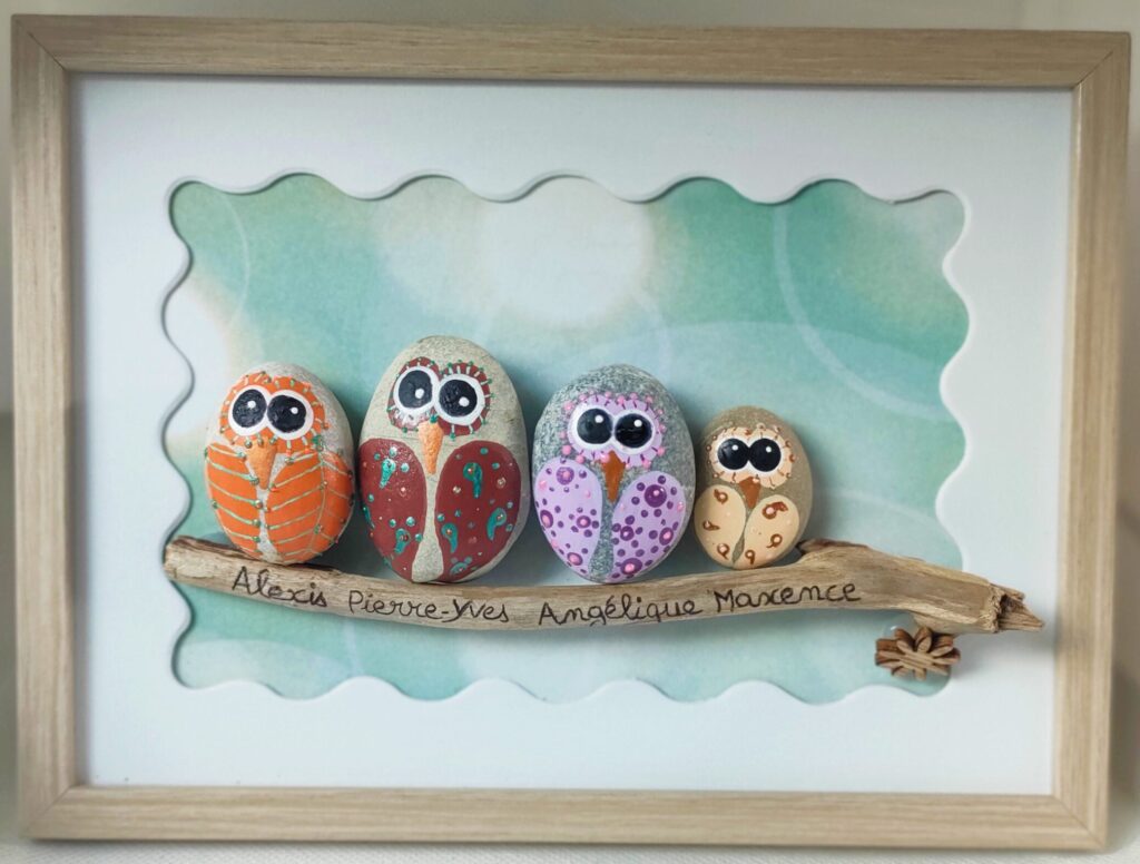 cadre moyen bois brut avec galets peints famille chouettes perchées sur branche en bois flotté avec les prénoms les galets de Marion commande artisanale personnalisée entièrement réalisée à la main avec des produits naturels